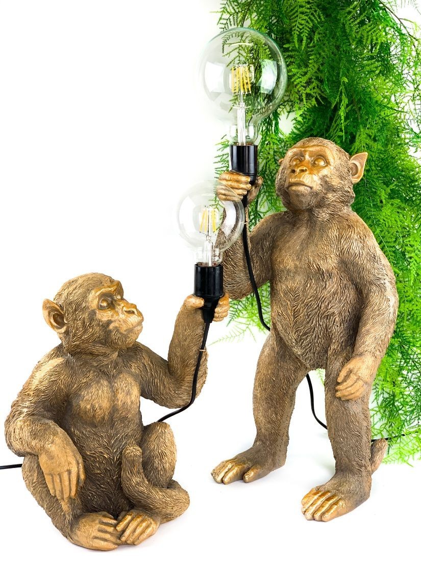 Modern majomlámpa. A szépen kidolgozott arany majom kezében lámpával.