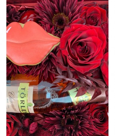 Enchanting gift package with red flowers, champagne and cake