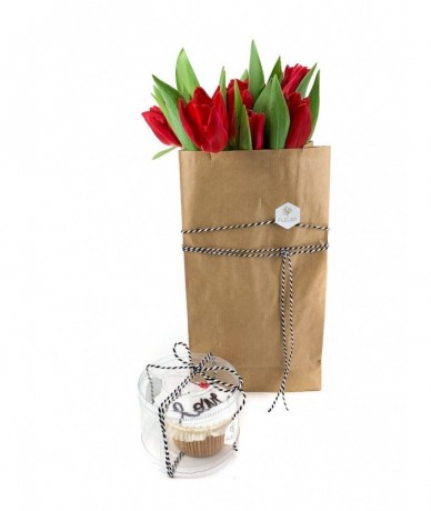 A paper bag packet of red tulips with a love muffin