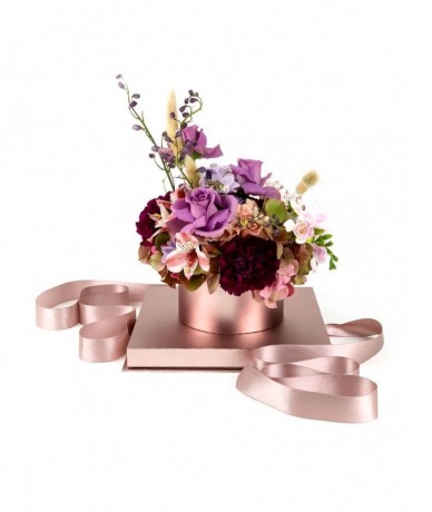 Luxurious rosé and transparent gift box with a small mixed bouquet