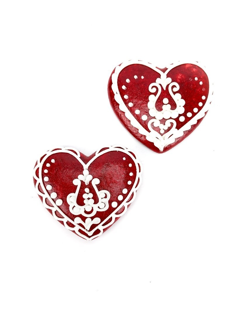 Handmade gingerbread heart in red decorated with white Hungarian motives