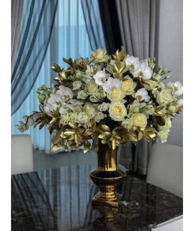 Orchids and roses in a majestic pairing with golden leaves