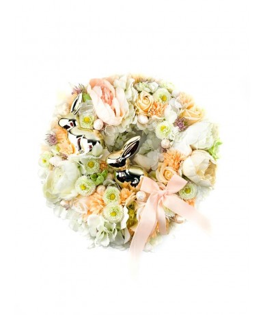Wreath from small pastel flowers and shiny Easter rabbits